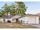 Charming one-story home featuring a well-maintained yard and attached garage, complemented by mature trees at 7333 Radiant Cir, Orlando, FL 32810
