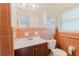 Bathroom featuring tile walls, a toilet, a sink with vanity, and a large mirror above the sink at 735 Baltimore Dr, Orlando, FL 32810