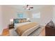 Bedroom with hardwood floors, a ceiling fan, a window, a comfortable bed with stylish decor, and ample natural light at 735 Baltimore Dr, Orlando, FL 32810