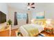 Bright bedroom featuring a ceiling fan, light hardwood floors, a window, and a comfortable bed with stylish decor at 735 Baltimore Dr, Orlando, FL 32810