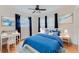 Bedroom featuring hardwood floors, windows on two walls, a ceiling fan, a desk, and a blue comforter at 735 Baltimore Dr, Orlando, FL 32810