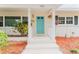 Welcoming front porch with a bright blue door and white columns offering classic curb appeal at 735 Baltimore Dr, Orlando, FL 32810