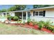 Charming home with a tidy lawn, a colorful flowerbed, and a bright blue front door at 735 Baltimore Dr, Orlando, FL 32810