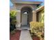 Covered front door entrance with tiled floor and garden to the side at 840 Lake Jackson Cir, Apopka, FL 32703