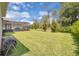 Large backyard with an expansive lawn, enclosed patio, and well-maintained landscaping at 8768 Sonoma Coast Dr, Winter Garden, FL 34787