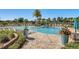 Relaxing community pool area with plenty of lounge chairs, lush landscaping, and a serene waterfront view at 8768 Sonoma Coast Dr, Winter Garden, FL 34787