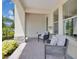 Covered front porch featuring brick pavers, cozy seating, and decorative stone accents on the support columns at 8768 Sonoma Coast Dr, Winter Garden, FL 34787