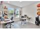 Office with two windows, tiled floors, two desks, and charming decor on shelves and the walls at 8768 Sonoma Coast Dr, Winter Garden, FL 34787