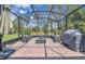 Relaxing screened-in patio with brick flooring, a built-in fire pit, and an outdoor kitchen area at 8768 Sonoma Coast Dr, Winter Garden, FL 34787