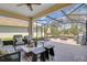 Relaxing screened-in patio with comfortable seating and a stone fire pit at 8768 Sonoma Coast Dr, Winter Garden, FL 34787