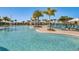 Large community pool featuring crystal clear water, poolside seating, umbrellas and lush tropical landscaping at 8768 Sonoma Coast Dr, Winter Garden, FL 34787