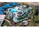 Stunning aerial view of the community pool, featuring lazy rivers, slides, and lush landscaping at 880 Paradise Dr, Davenport, FL 33897