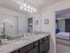 Bathroom with dual sinks, granite countertop, and an entrance to the bedroom at 880 Paradise Dr, Davenport, FL 33897