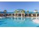 Inviting community pool with palm trees, modern architecture, and clear blue water at 880 Paradise Dr, Davenport, FL 33897