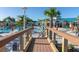 Scenic community pool view from a wooden bridge, showcasing umbrellas, lounge chairs, and palm trees at 880 Paradise Dr, Davenport, FL 33897