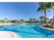 Resort-style pool with palm trees, lounge chairs, and colorful umbrellas on a clear, sunny day at 880 Paradise Dr, Davenport, FL 33897