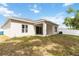 Backyard with a covered patio, well-maintained lawn, and privacy fence at 928 Avenal Ln, Davenport, FL 33837