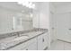 Bathroom featuring double vanity, granite countertops, large mirror and glass enclosed shower at 928 Avenal Ln, Davenport, FL 33837