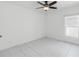 Clean, minimalist bedroom with tile floors, a ceiling fan, and a bright window overlooking the yard at 928 Avenal Ln, Davenport, FL 33837