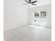 Minimalist bedroom features tile flooring, a large window, and ample natural light at 928 Avenal Ln, Davenport, FL 33837