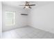 Bright bedroom featuring tile flooring, ceiling fan, a floating shelf, and natural light at 928 Avenal Ln, Davenport, FL 33837