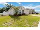 Landscaped front yard of a single-story home with green grass, a brick driveway, and an attached two-car garage at 928 Avenal Ln, Davenport, FL 33837
