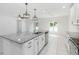 Open kitchen features a large island with granite countertops, stainless steel appliances, and white cabinetry at 928 Avenal Ln, Davenport, FL 33837