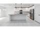 Spacious kitchen with white cabinets, stainless steel appliances, granite countertops, and modern pendant lighting at 928 Avenal Ln, Davenport, FL 33837