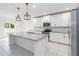 Modern kitchen with white cabinets, stainless steel appliances, granite countertops, and decorative pendant lights at 928 Avenal Ln, Davenport, FL 33837