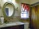 Bright bathroom with granite counters, large oval mirror, and a decorative sconce at 929 Monroe Harbor Pl, Sanford, FL 32773