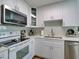 Modern kitchen with stainless steel appliances, white cabinets, and light countertops at 929 Monroe Harbor Pl, Sanford, FL 32773