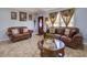 Inviting living room featuring tile floors, natural light, and comfortable leather seating at 929 Monroe Harbor Pl, Sanford, FL 32773