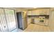 Bright kitchen features stainless steel refrigerator, white cabinets, tiled floors, and modern backsplash at 980 Canal View Blvd # N2, Port Orange, FL 32129