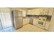 Well-lit kitchen features stainless steel appliances, white cabinets, tiled floor, and backsplash at 980 Canal View Blvd # N2, Port Orange, FL 32129