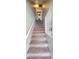Carpeted stairs lead up to a laundry closet with a stacked washer and dryer at 980 Canal View Blvd # N2, Port Orange, FL 32129