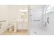 Bright bathroom featuring a toilet and accessible shower with grab bars for safety at 13241 Fountainbleau Dr, Clermont, FL 34711