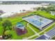 Aerial view of community tennis courts, playground, and lush landscaping near the lake, offering recreational amenities at 13241 Fountainbleau Dr, Clermont, FL 34711