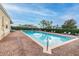 Community pool surrounded by brick pavers, privacy hedges, and lounge chairs, offering a relaxing and refreshing escape at 13241 Fountainbleau Dr, Clermont, FL 34711