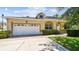 Inviting home with a two-car garage, well-maintained lawn, and a welcoming entrance at 13241 Fountainbleau Dr, Clermont, FL 34711