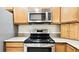 Well-equipped kitchen featuring a stainless steel microwave and electric range at 13241 Fountainbleau Dr, Clermont, FL 34711