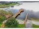 Aerial view of a lake pier and boat launch area with a gazebo, surrounded by lush greenery, providing waterfront access at 13241 Fountainbleau Dr, Clermont, FL 34711