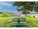 Community picnic area with green table in a grassy spot offering lake views and recreational opportunities by the water at 13241 Fountainbleau Dr, Clermont, FL 34711