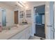 Well-lit bathroom featuring a double vanity, decorative beach-themed elements, and an open doorway to a workout area at 3302 Stonegate Dr, Ocoee, FL 34761