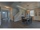 Open dining room with modern light fixture and hardwood flooring, adjacent to staircase and main entry at 3302 Stonegate Dr, Ocoee, FL 34761