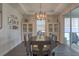 Elegant dining room with a decorative chandelier, white cabinets, and sliding glass doors to the patio at 3302 Stonegate Dr, Ocoee, FL 34761
