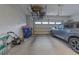Spacious garage with a parked car, lawnmower, trash bins, and overhead storage at 3302 Stonegate Dr, Ocoee, FL 34761