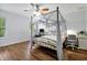 Bedroom features a bed with a canopy and view to the desk space next to window at 10374 Park Commons Dr, Orlando, FL 32832