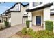 Charming townhome with blue door, manicured landscaping, and brick paved driveway at 10374 Park Commons Dr, Orlando, FL 32832
