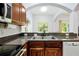 Kitchen area featuring granite countertops, stainless steel sink, dark cabinets, and a view of the backyard at 10374 Park Commons Dr, Orlando, FL 32832