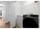 Well-organized laundry room with modern washer and dryer, storage shelves, and a tiled floor at 10374 Park Commons Dr, Orlando, FL 32832